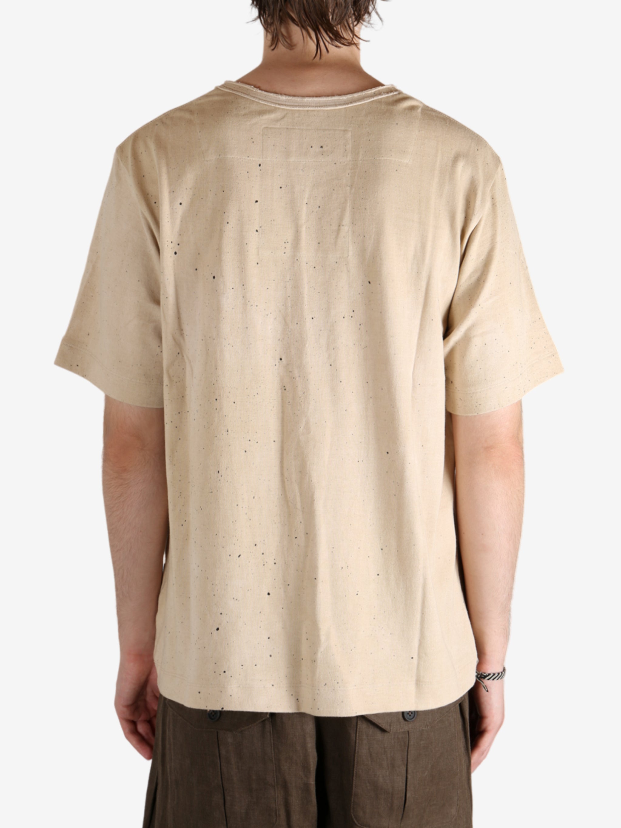 Tan t-shirt worn by a person, showing the t-shirt's fit