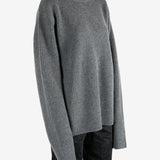 Grey knitwear worn by a person, showing the knitwear's fit