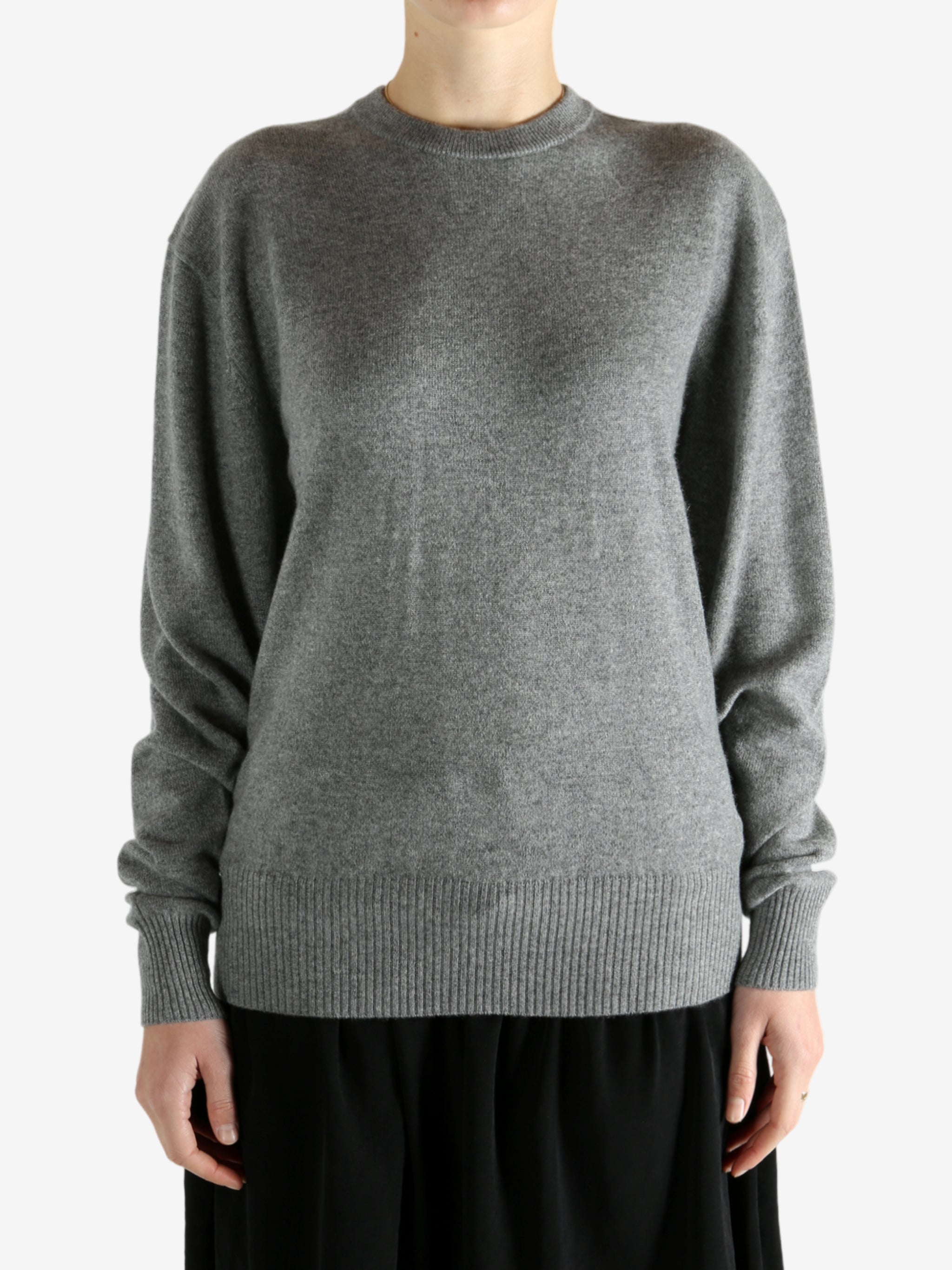 Grey knitwear worn by a person, showing the knitwear fit