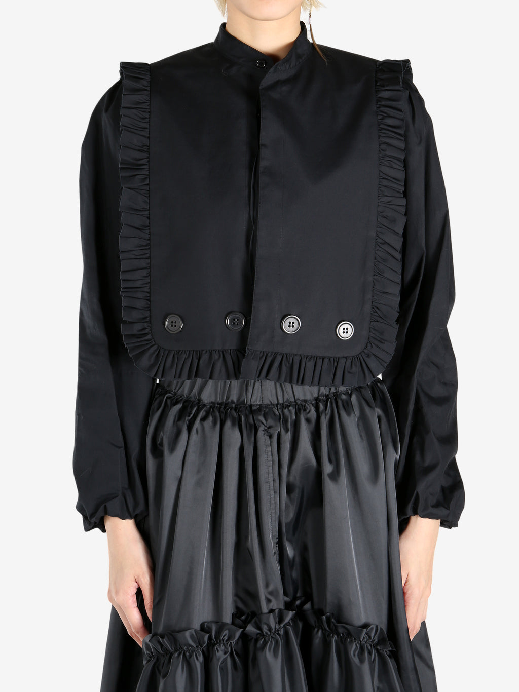 Black tops worn by a person, showing the tops fit
