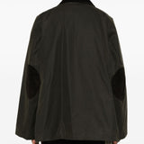 Green jacket worn by a person, showing the jacket’s fit