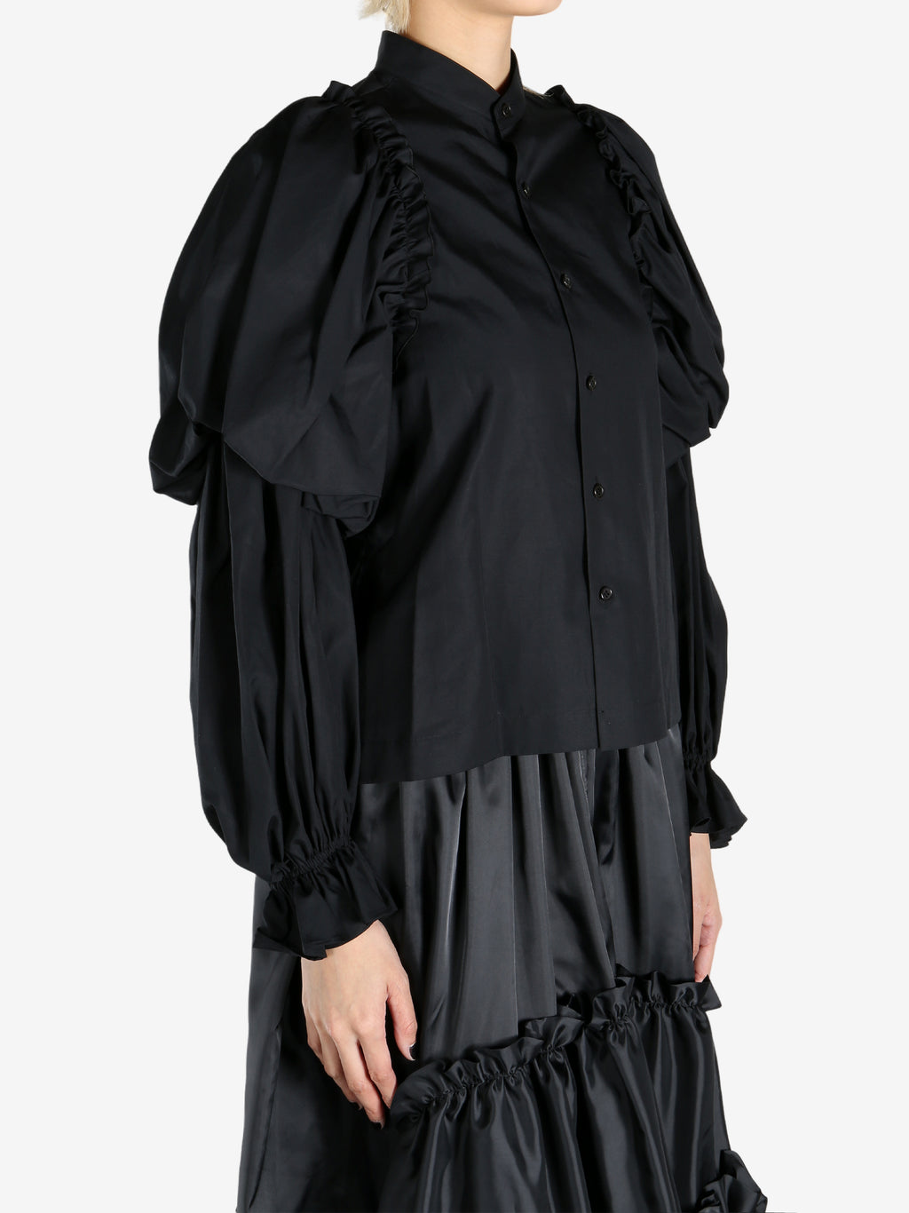 Black tops worn by a person, showing the tops fit