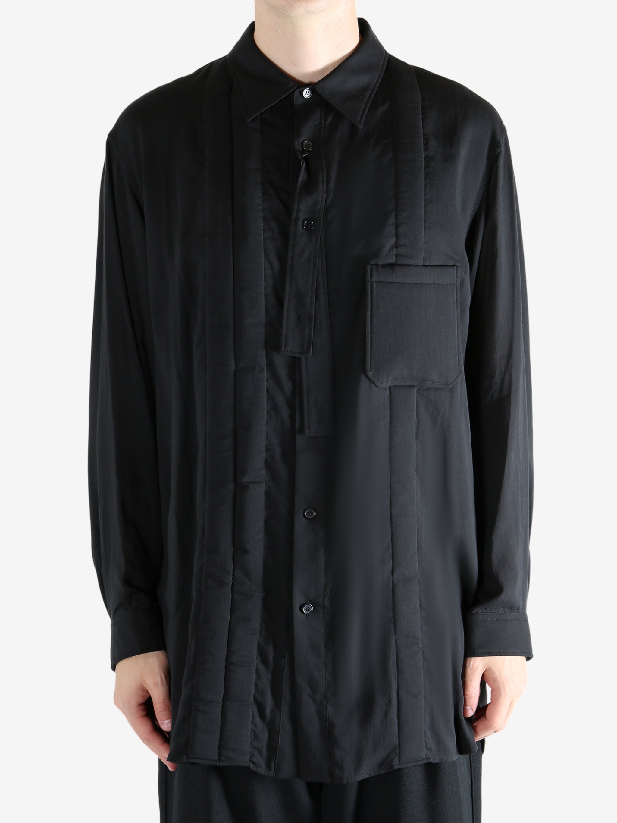 Black shirt worn by a person, showing the shirt's fit