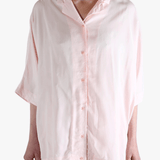 Light pink button-up shirt worn by a person,showing the shirt's fit