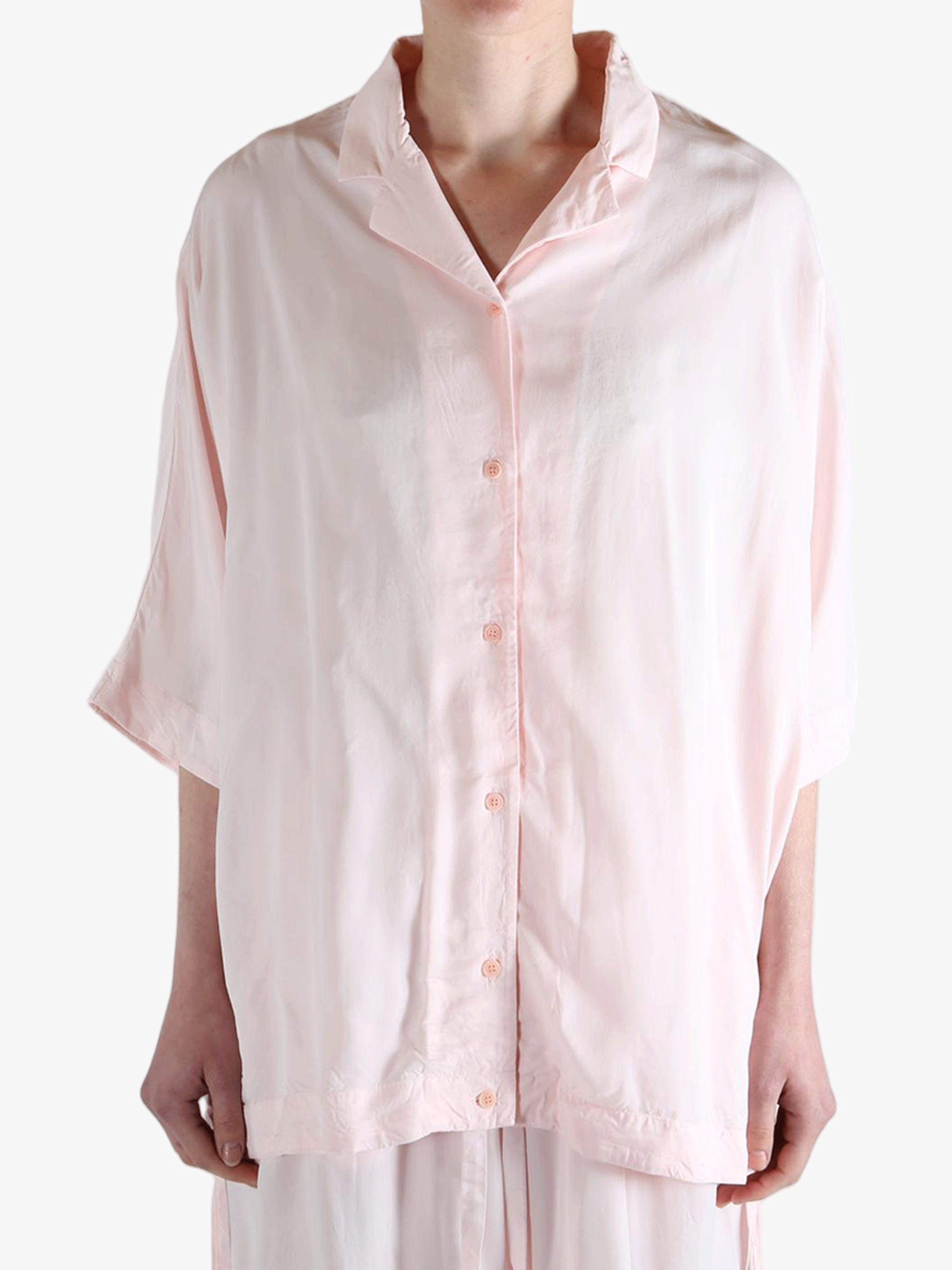 Light pink button-up shirt worn by a person,showing the shirt's fit