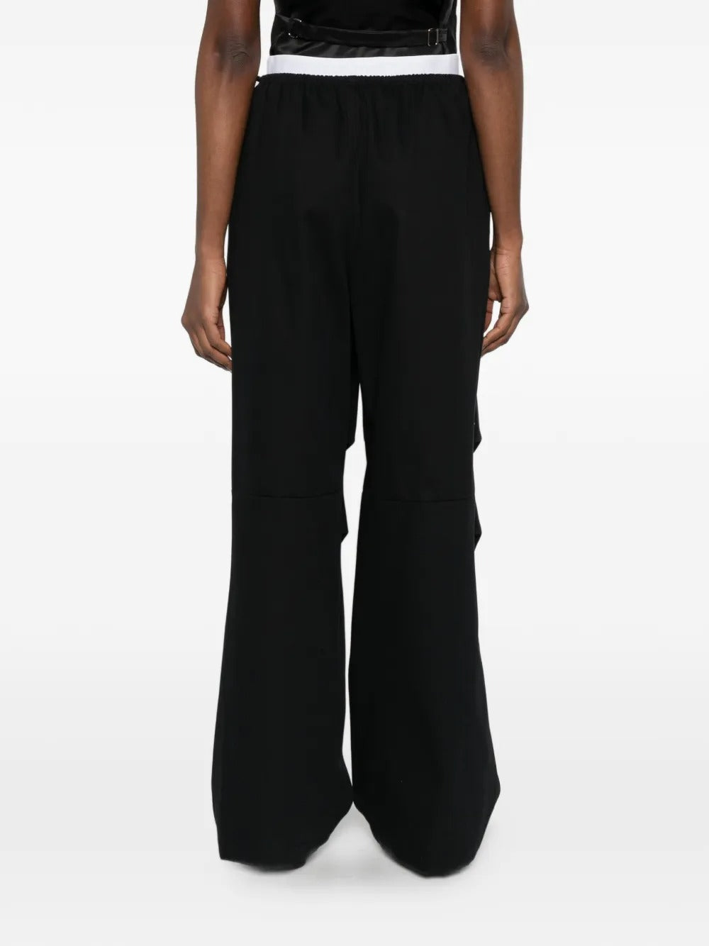 Black pants worn by a person, showing the pants 's fit