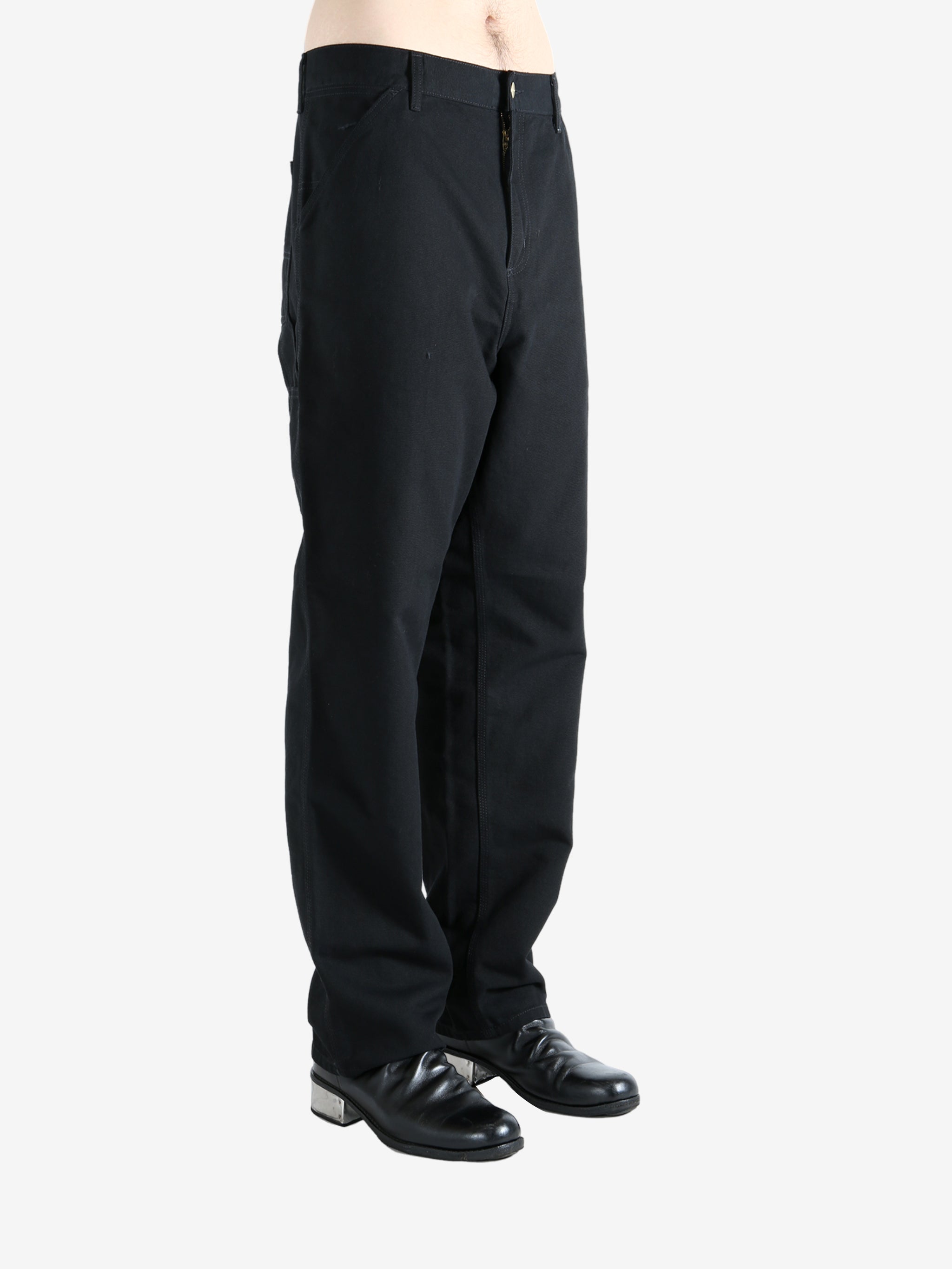Black pants worn by a person, showing the pants' fit