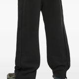 Black pants worn by a person, showing the pants' fit