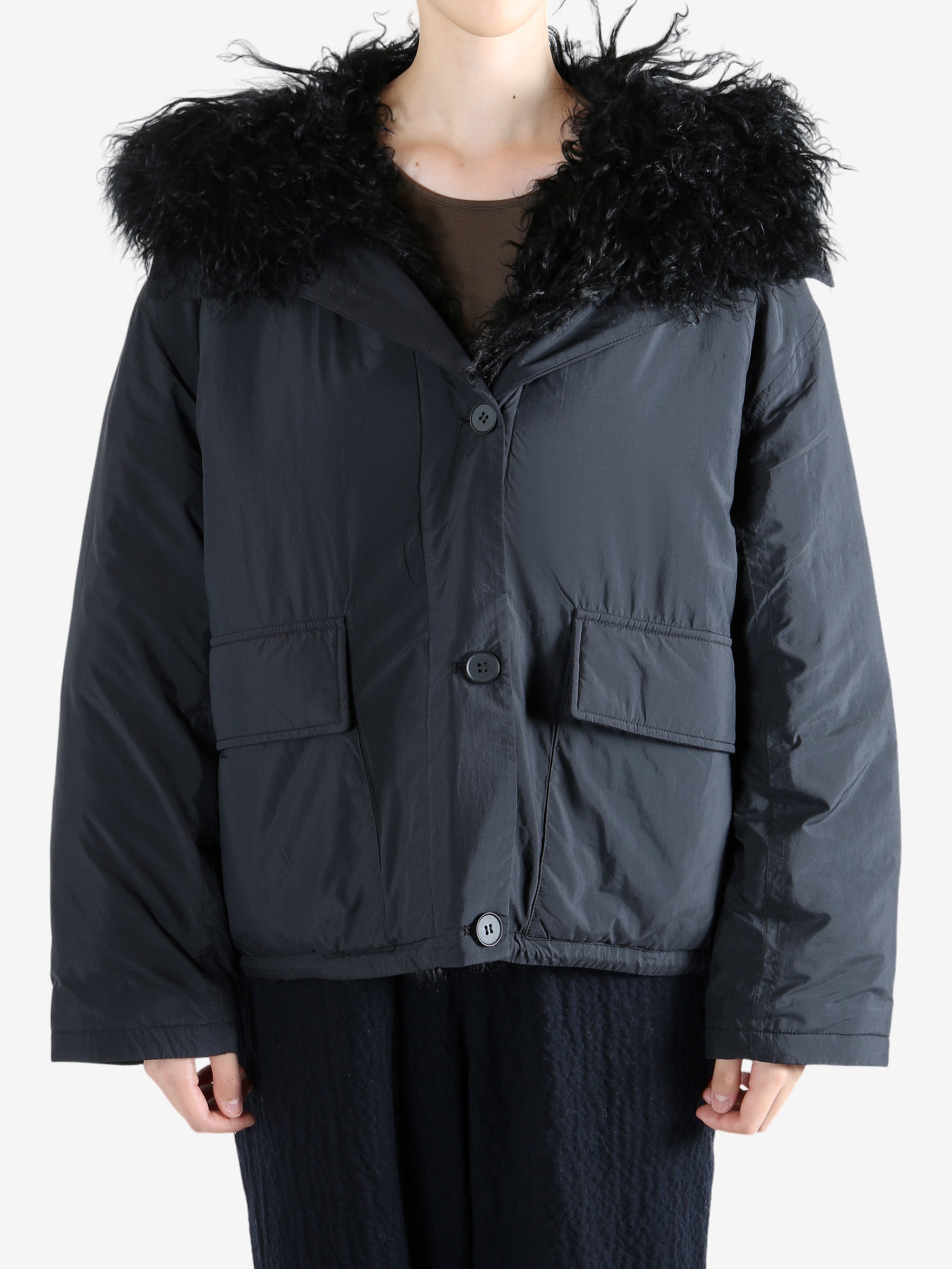 Black coat worn by a person, showing the coat's fit