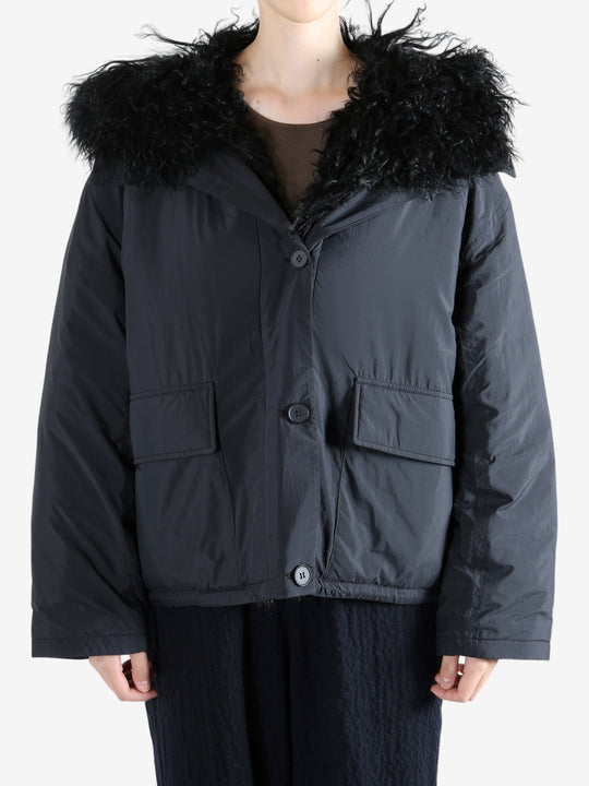 Black coat worn by a person, showing the coat's fit