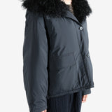 Black coat worn by a person, showing the coat's fit