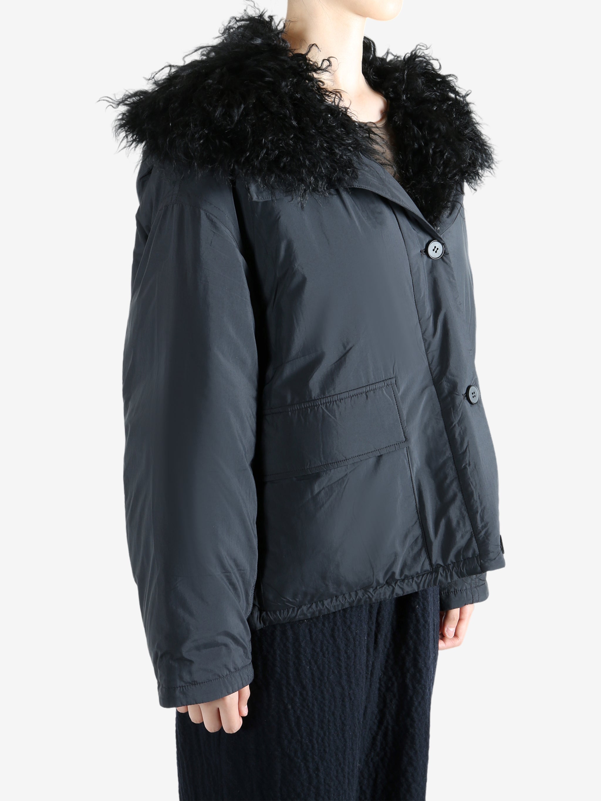 Black coat worn by a person, showing the coat's fit