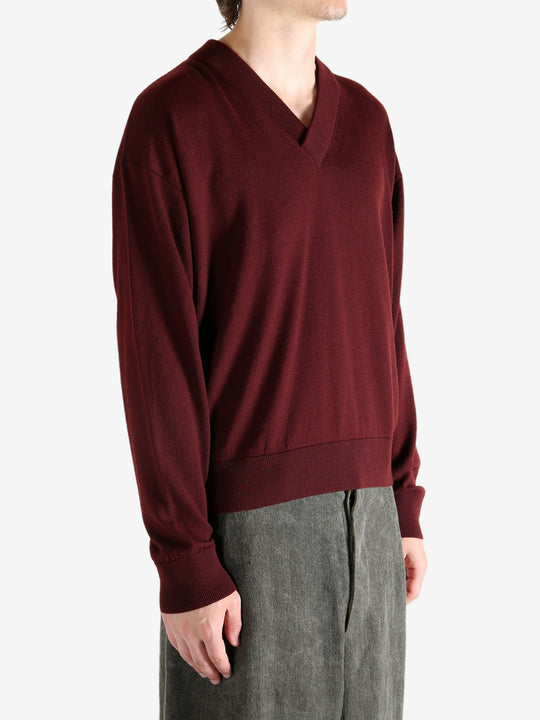 Red sweater worn by a person, showing the sweater's fit