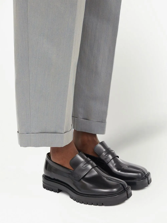Black loafer worn by a person, showing the loafer's fit