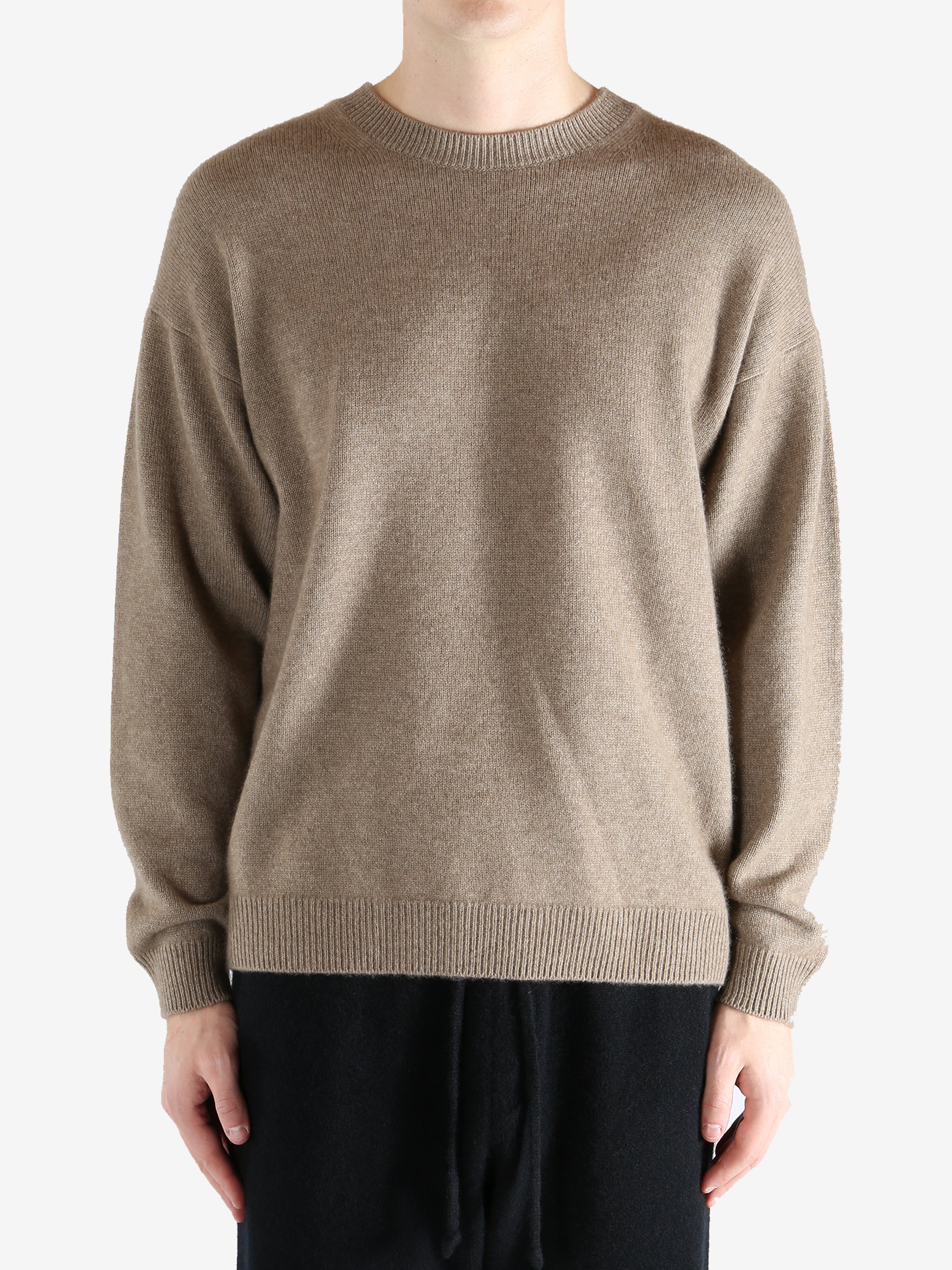 Brown knitwear worn by a person, showing the knitwear's fit
