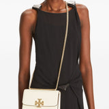 White bag carried by a person, showing the bag’s fit