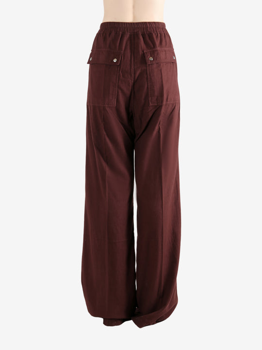 Burgundy pants worn by a person, showing the pants fit