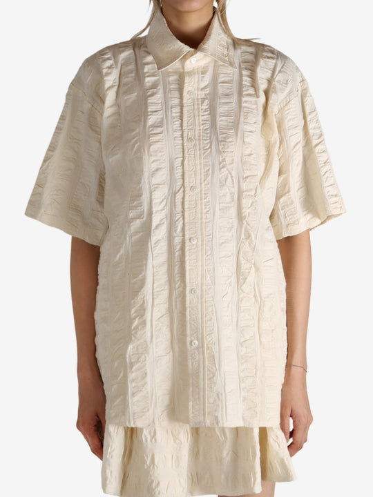 White shirt worn by a person, showing the shirt's fit