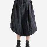 Grey skirts worn by a person, showing the skirts fit