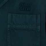 Close up of green coats, showing texture of the gabardine fabric