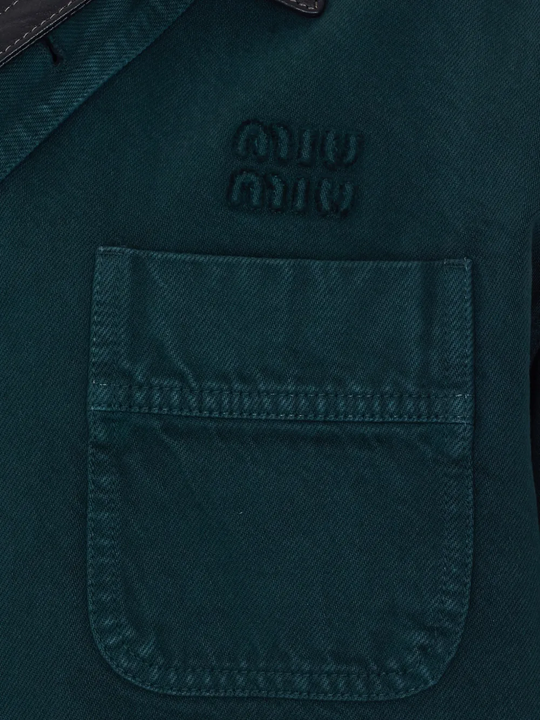 Close up of green coats, showing texture of the gabardine fabric