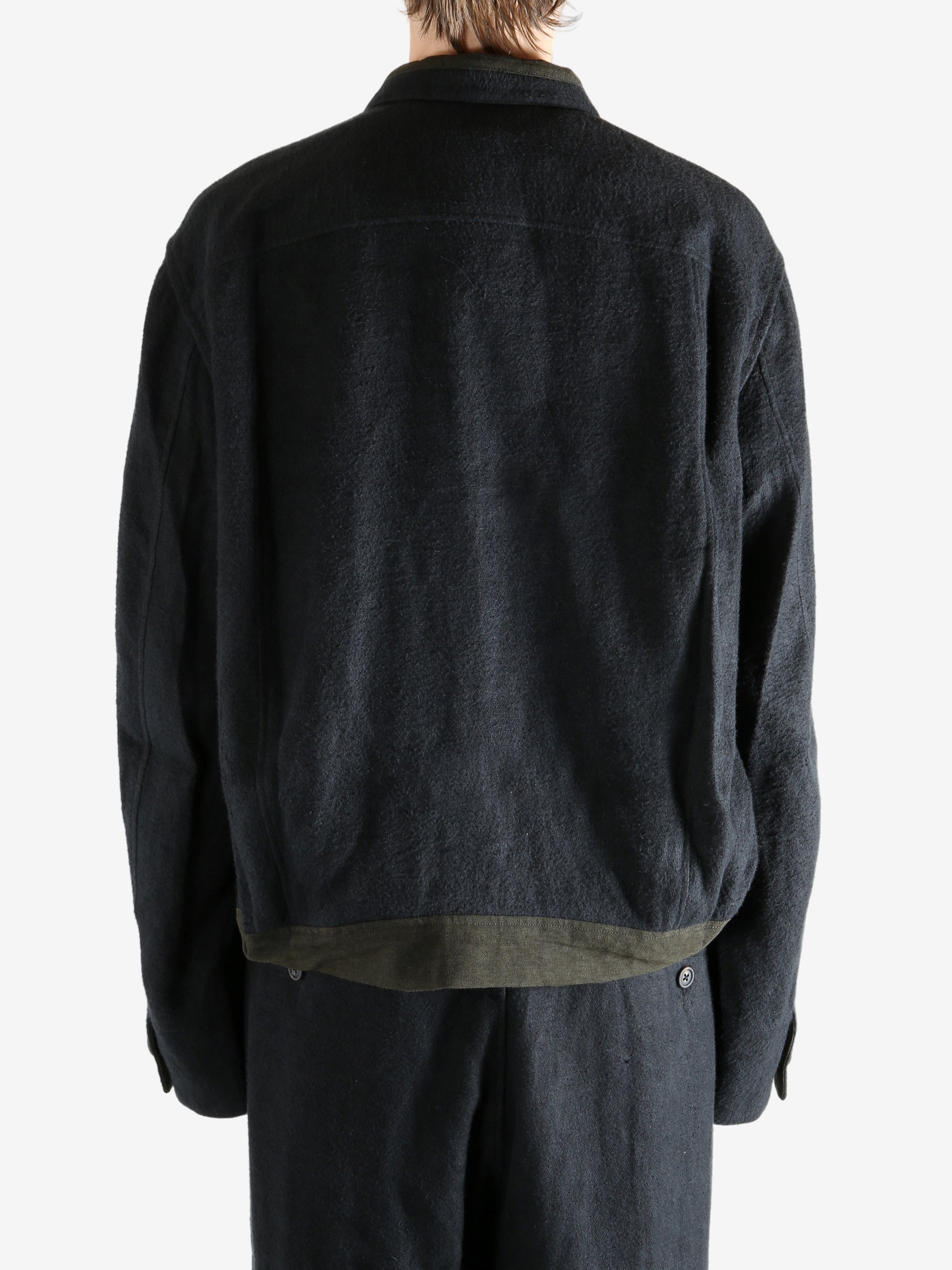 Black jacket worn a person, showing the jacket's fit