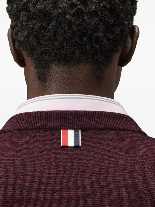 Burgundy knitwear worn by a person, showing the knitwear fit