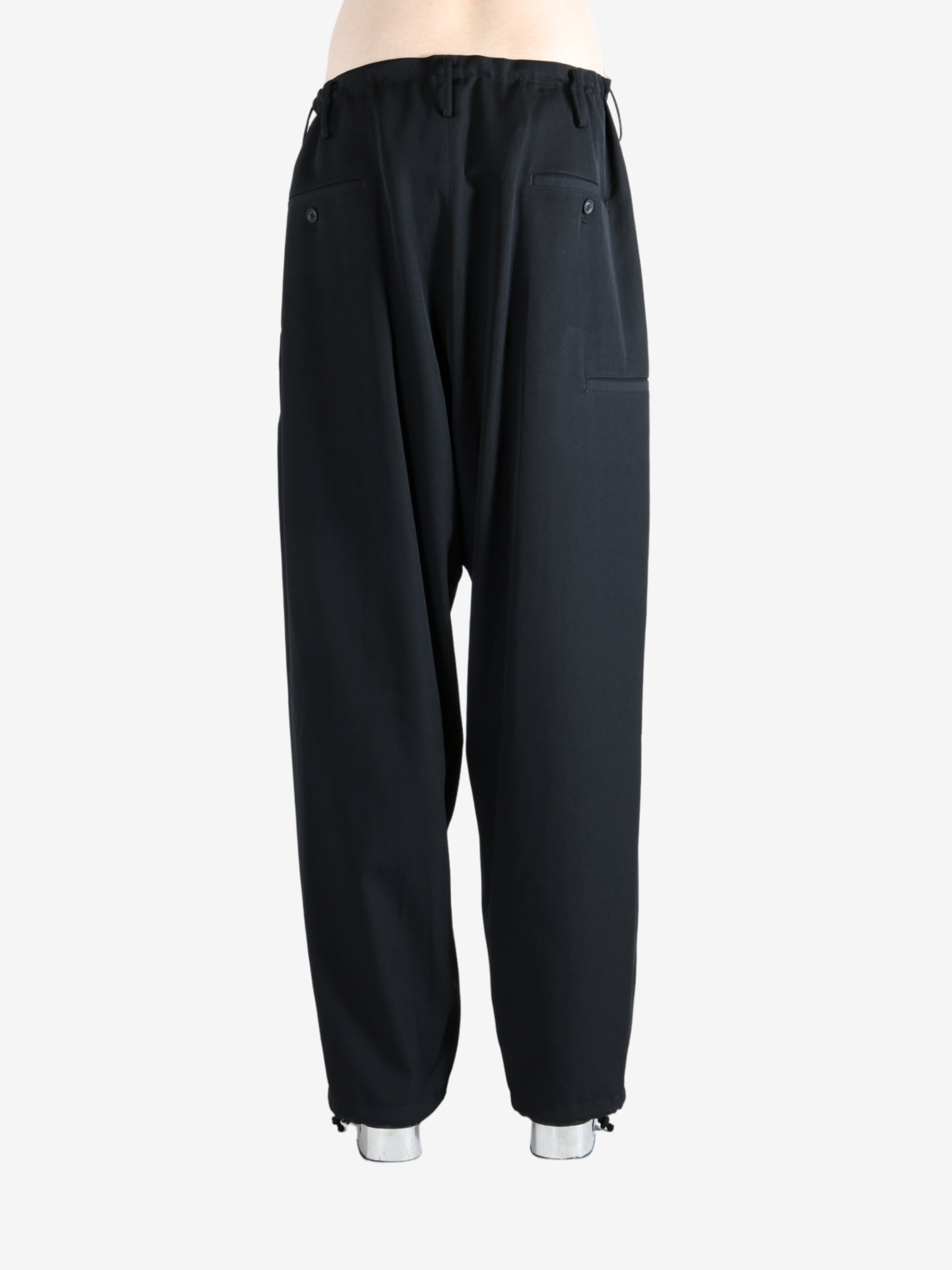 Black pants worn by a person, showing the pants' fit