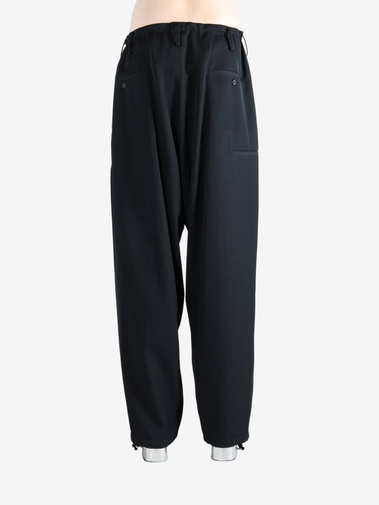 Black pants worn by a person, showing the pants' fit