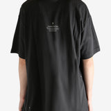 Black tee worn by a person, showing the tee"s fit