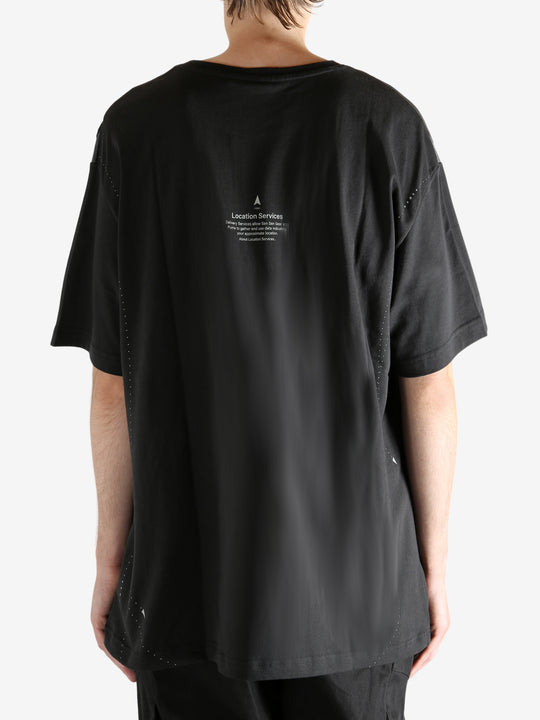 Black tee worn by a person, showing the tee"s fit