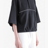 Black shirts worn by a person, showing the shirts' fit 
