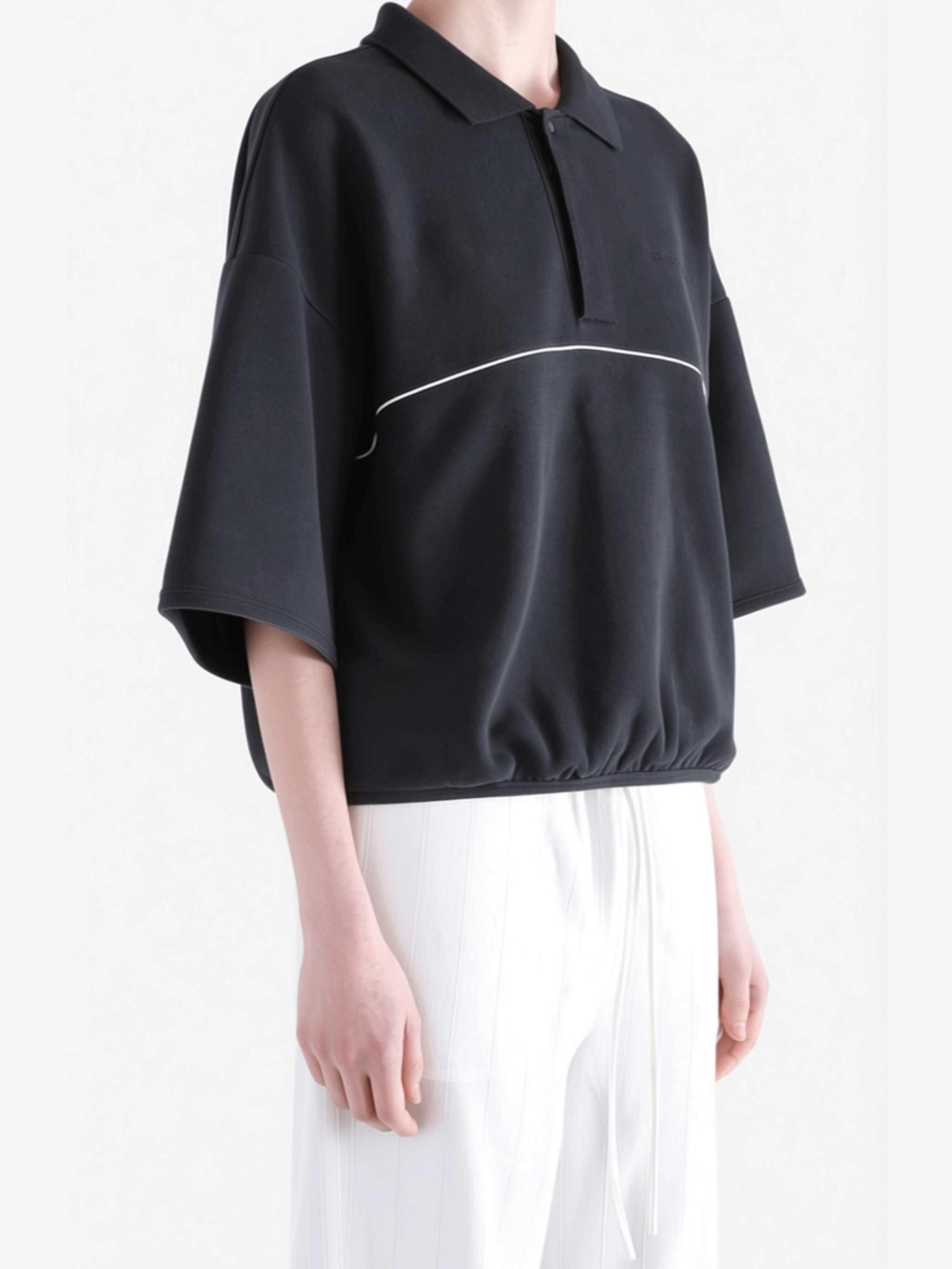 Black shirts worn by a person, showing the shirts' fit 