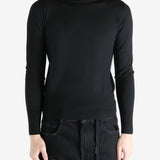 Black sweater worn by a person, showing the sweater's fit