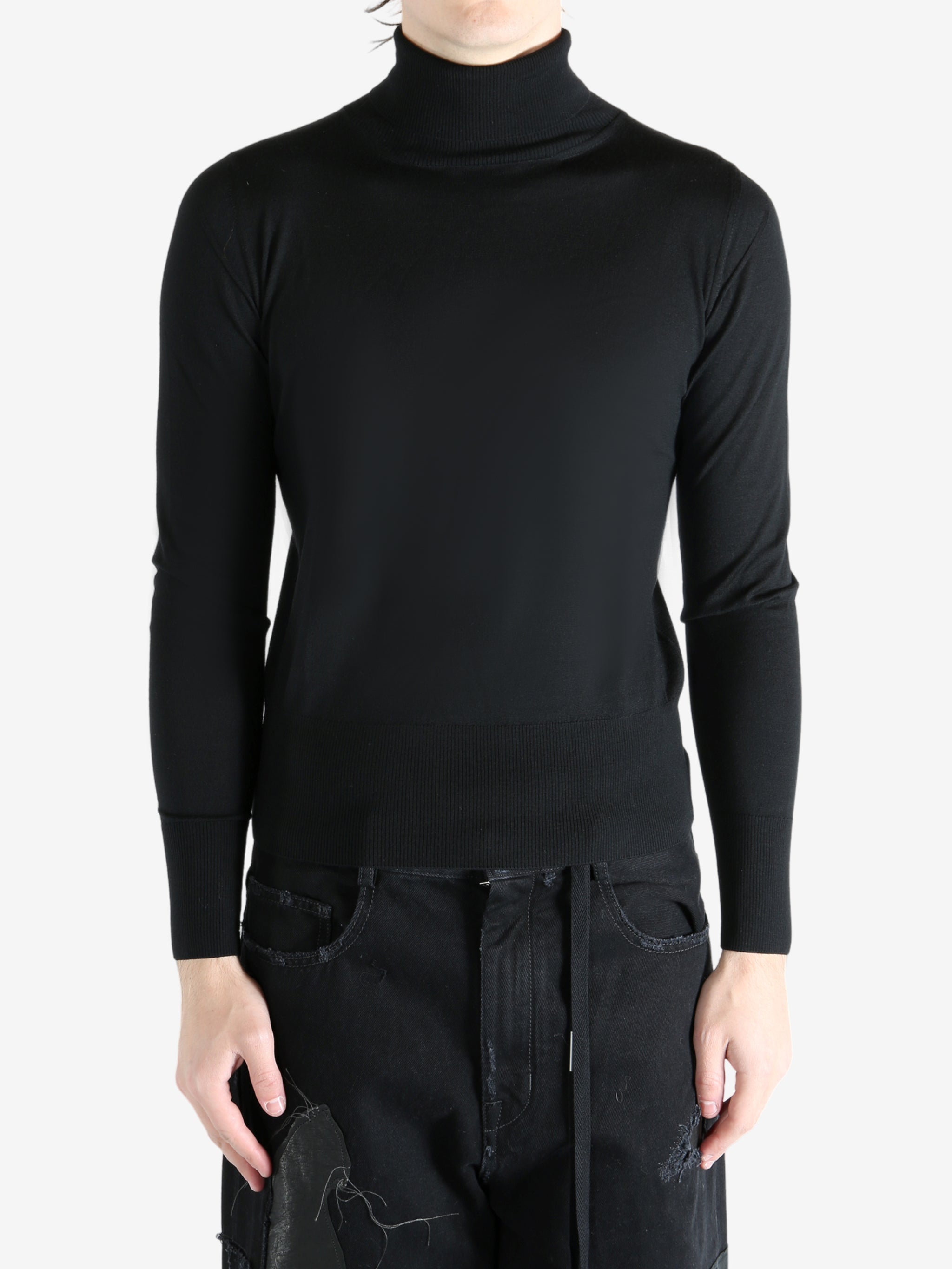 Black sweater worn by a person, showing the sweater's fit