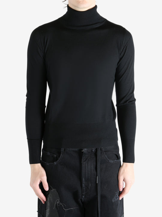Black sweater worn by a person, showing the sweater's fit