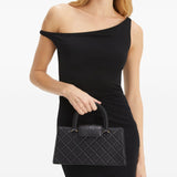 Black bag carried by a person, showing the bag’s fit