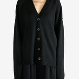 Black knitwear worn by a person, showing the knitwear's fit