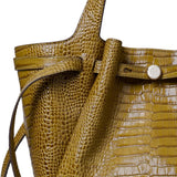 Close up of green bags, showing texture of the crocodile embossed leather fabric