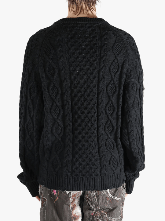 Black knitwear worn by a person, showing the knitwear's fit