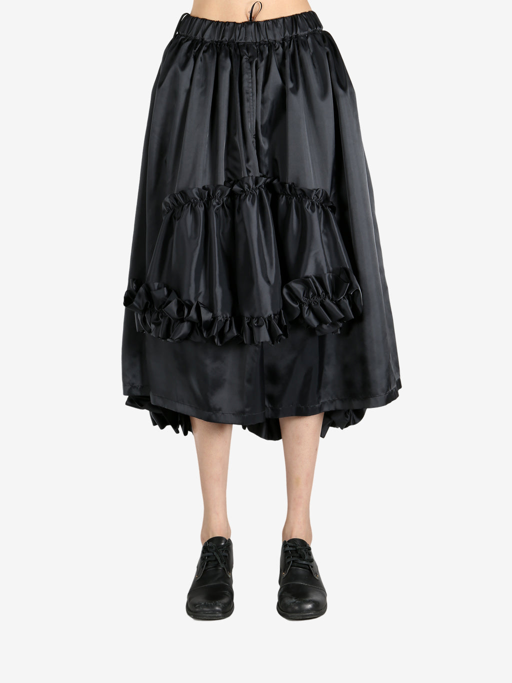 Black skirts worn by a person, showing the skirts fit