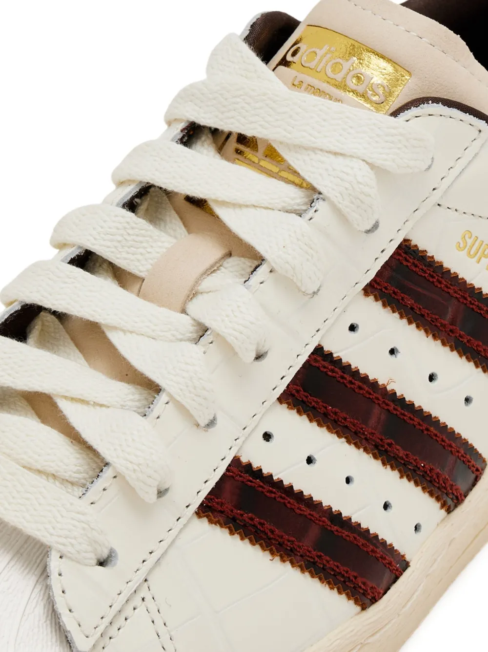 Close up of tan sneakers, showing texture of the textile and leather and rubber fabric