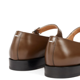 Close up of the brown shoes, showing texture of the leather fabric