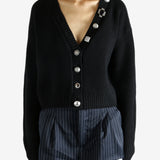 Black cardigan worn by a person, showing the cardigan’s fit