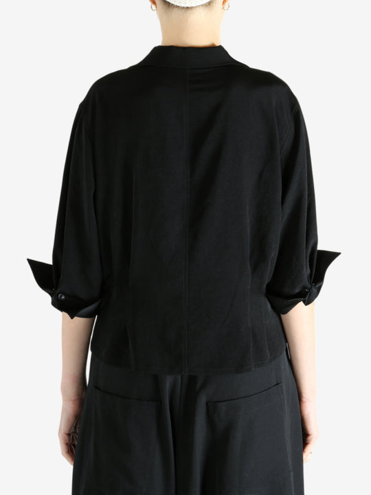 Black shirts worn by a person, showing the shirts fit