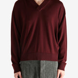 Red sweater worn by a person, showing the sweater's fit