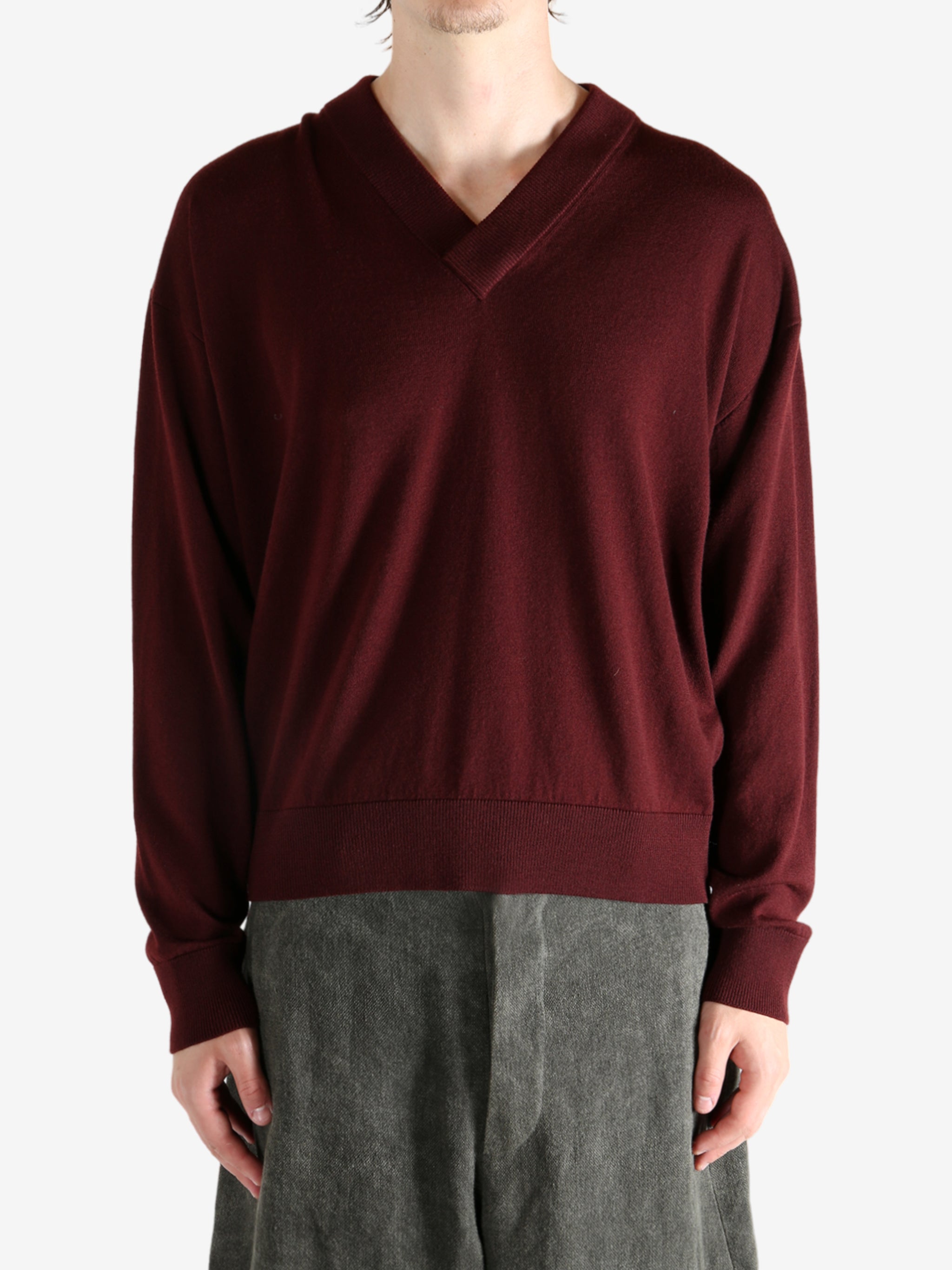 Red sweater worn by a person, showing the sweater's fit