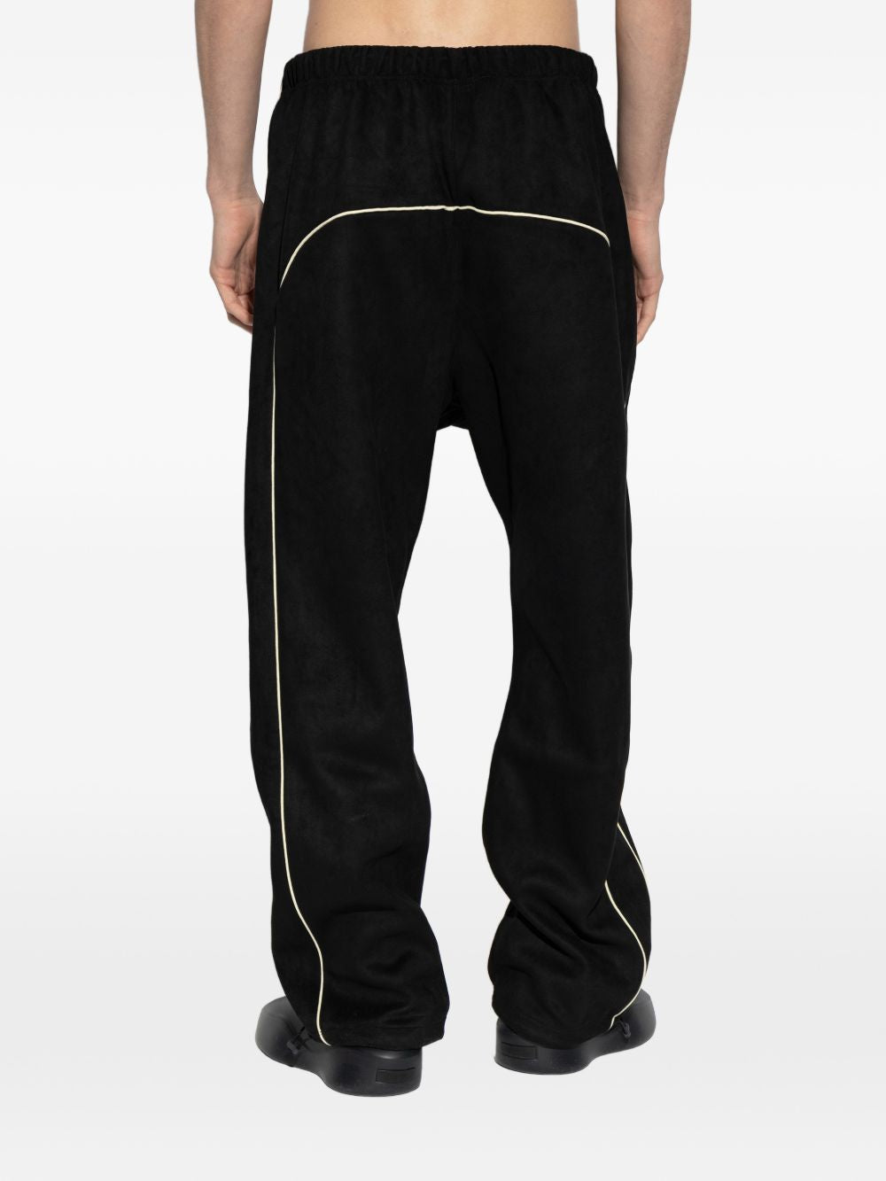 Black pants worn by a person, showing the pants' fit