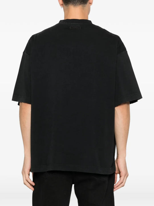 Black t-shirt worn by a person, showing the shirt's fit