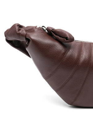 Close up of brown croissant bag, showing texture of the leather fabric